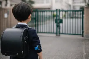 学校付近で子どもがキッズスマートウォッチを着けて登校するイメージ(学校ルールで使えないケースの説明用)