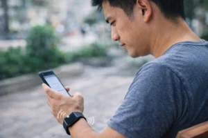 スマートウォッチの通知バイブに気づかずスマホを確認する人物のリアルなシーン